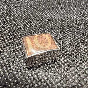 Silver "In Emergency Break Glass" silver charm with 10 Shilling note inside.